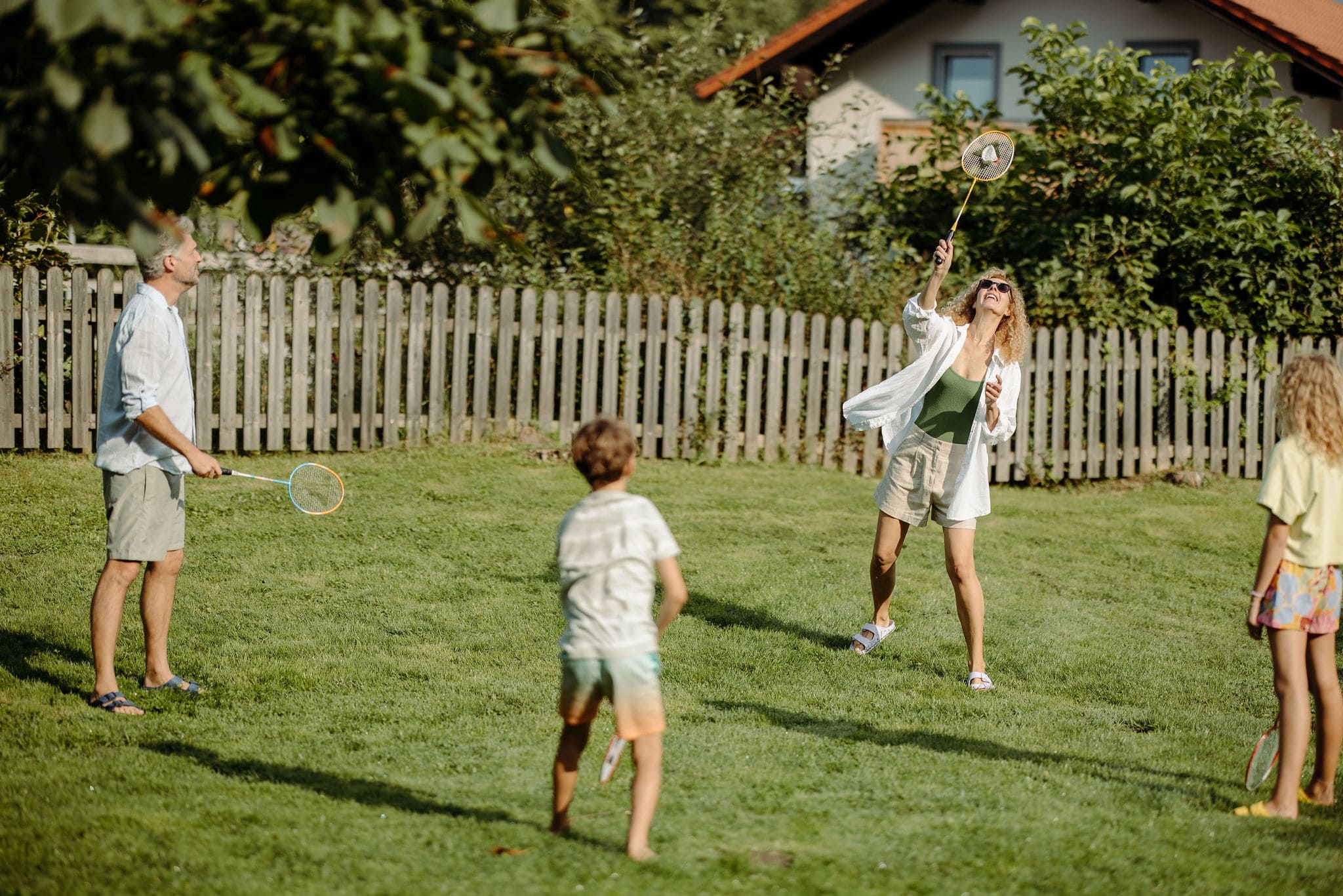 Familie spielt Federball im Garten