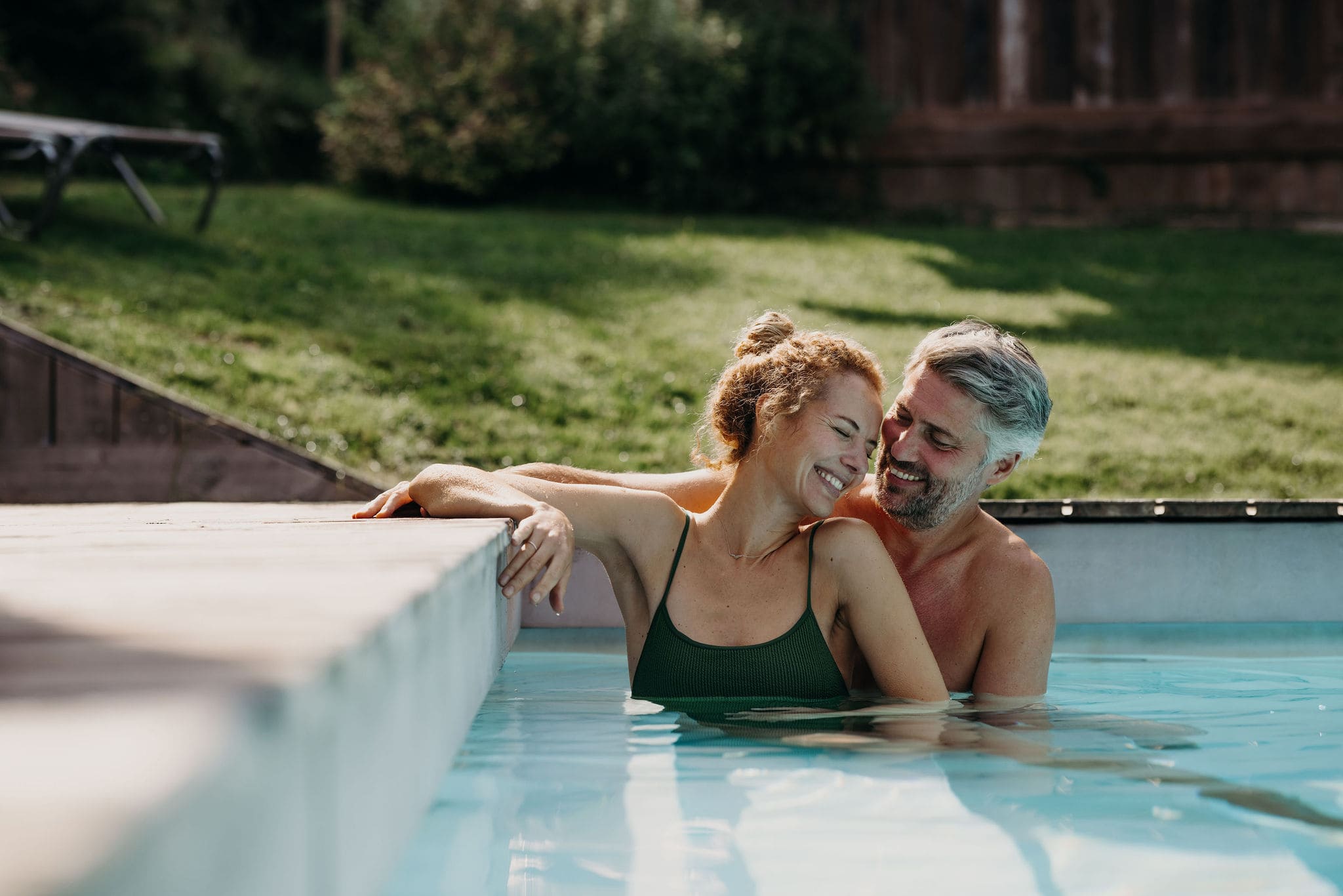 Paar lacht gemeinsam im Pool