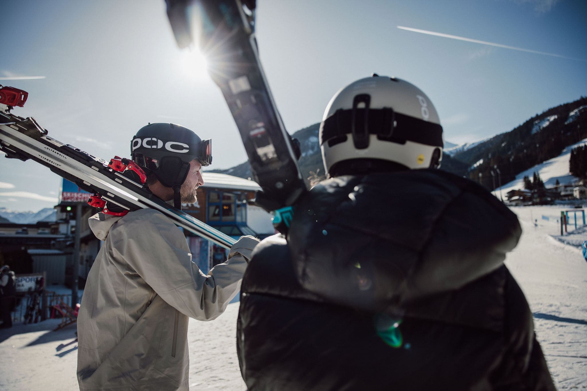 Zwei Skifahrer tragen ihre Ausrüstung